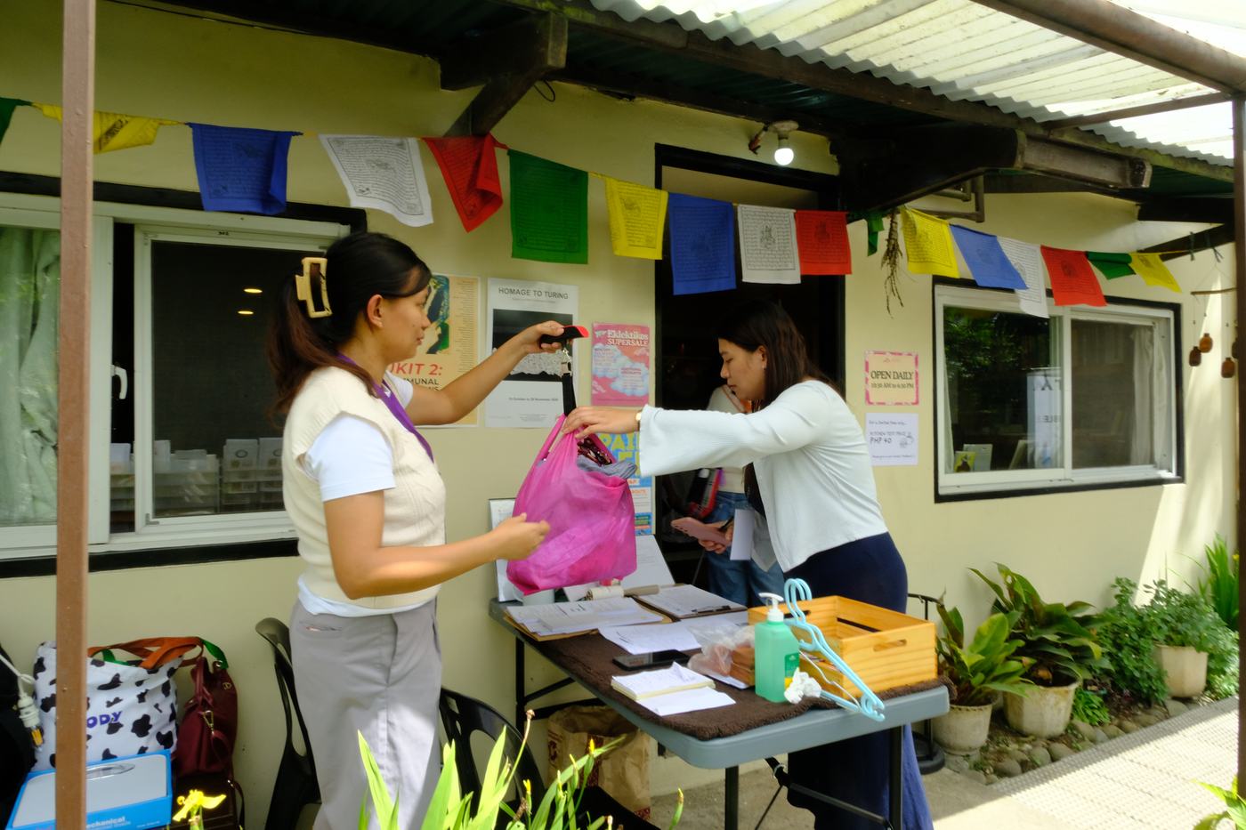 Volunteers weigh a bag of clothes at the intake table