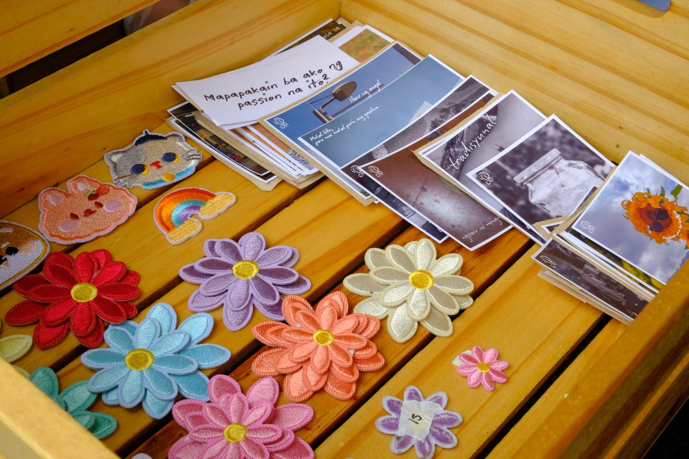 Embroidered flower patches and postcards on a wooden table