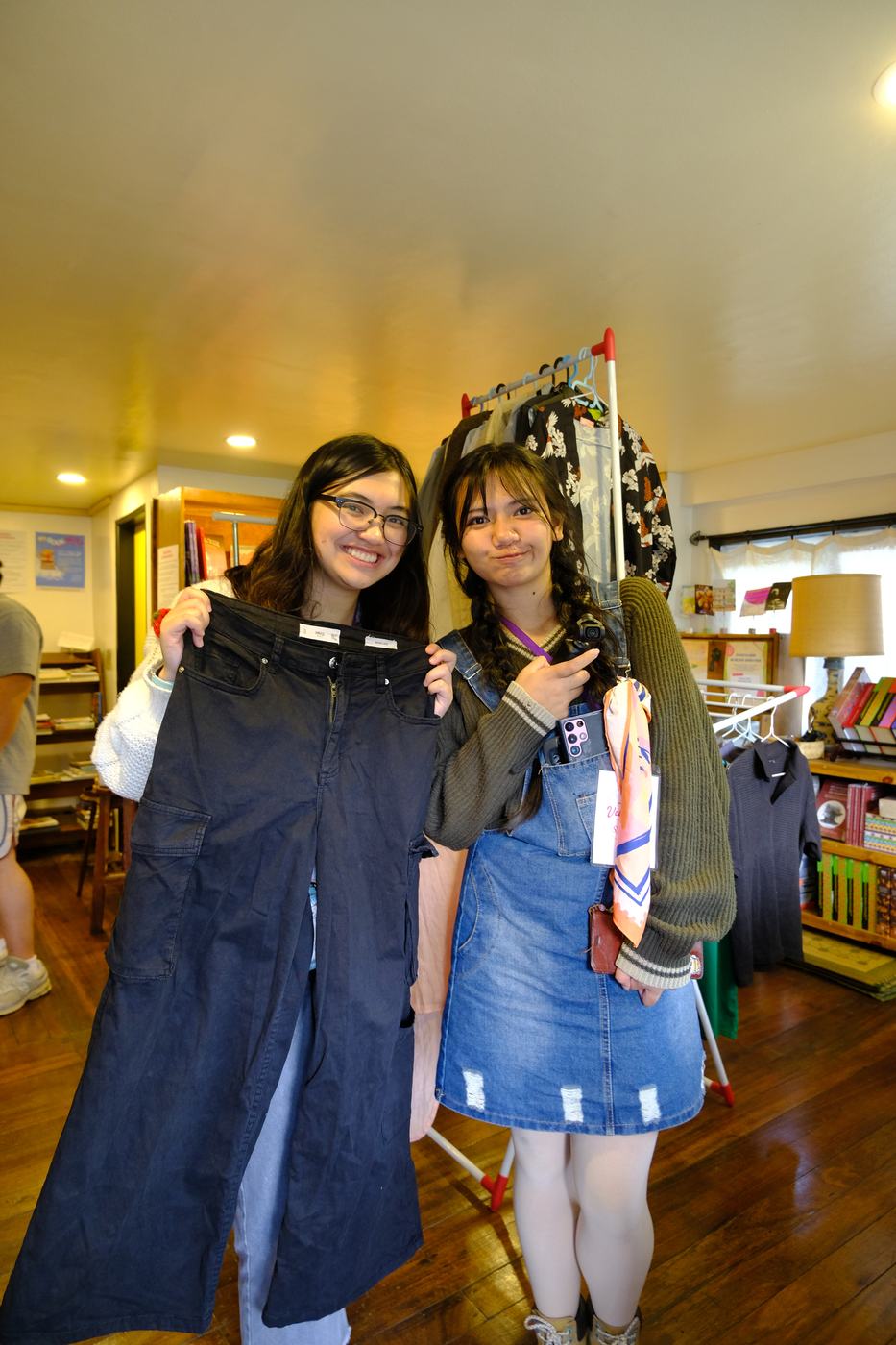 Two participants smile holding the denim pieces they found